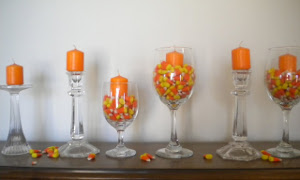 centros de mesa de halloween con golosinas, velas y copas.