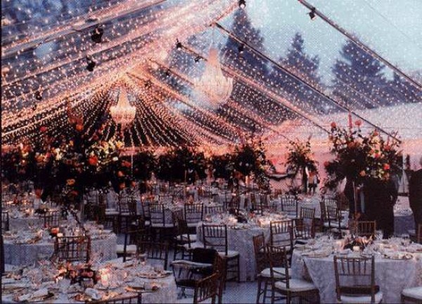 carpa transparente decorada con luces de navidad y candelabros